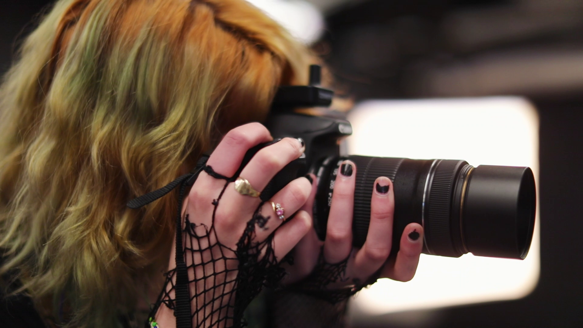 photography student looking through camera view finder
