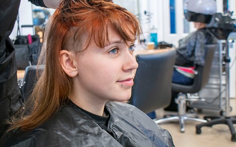 hairdressing student cutting hair