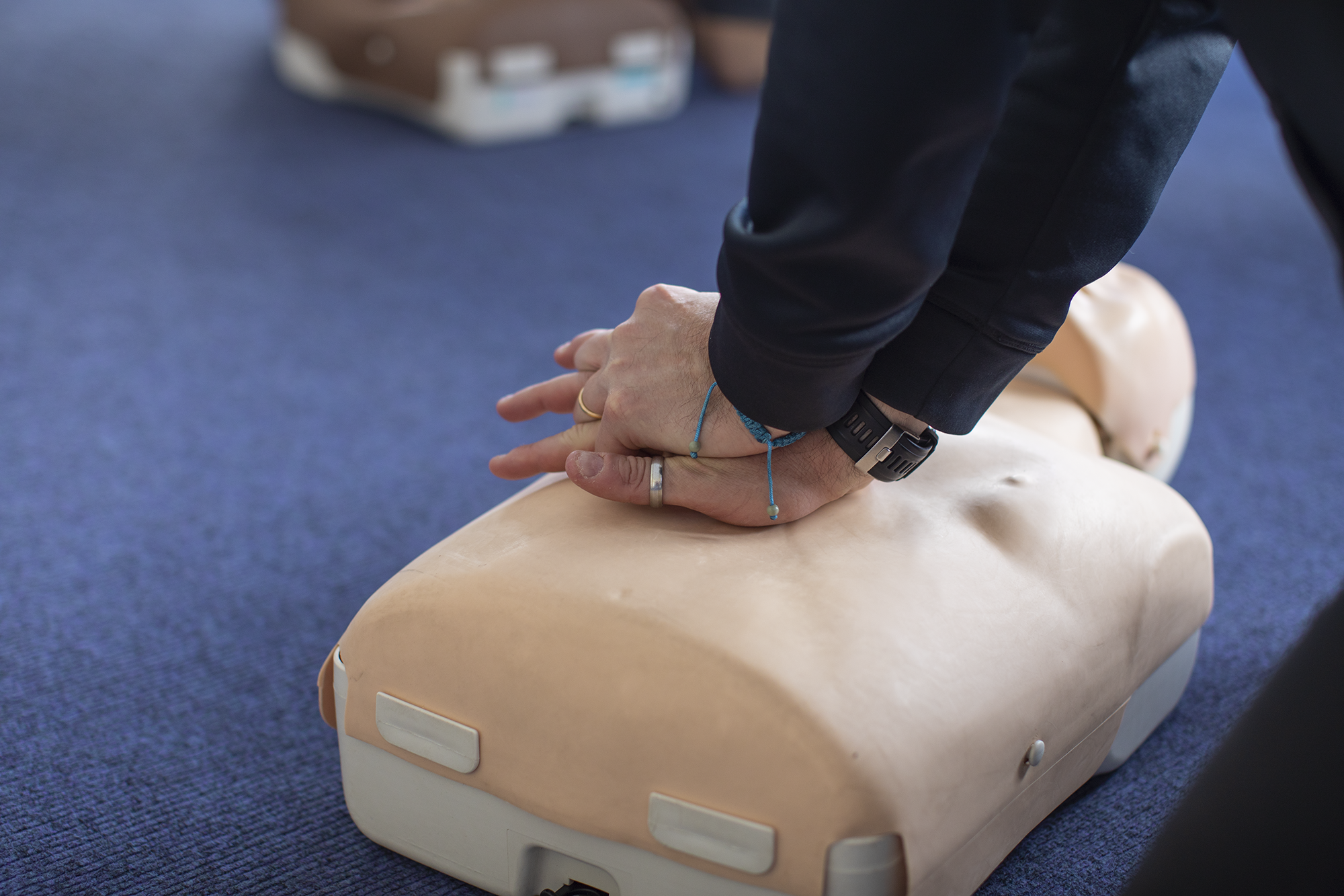 Hands performing CPR on dummy
