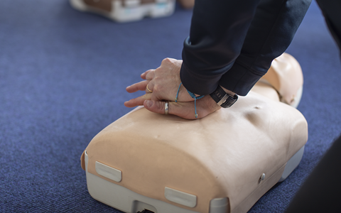 Hands performing CPR on dummy