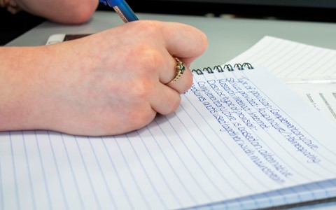 student writing in notepad