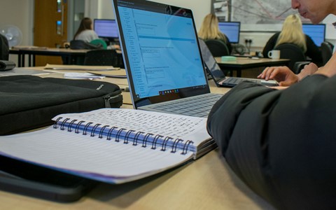 students with notebooks and laptops in classroom
