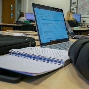 students with notebooks and laptops in classroom