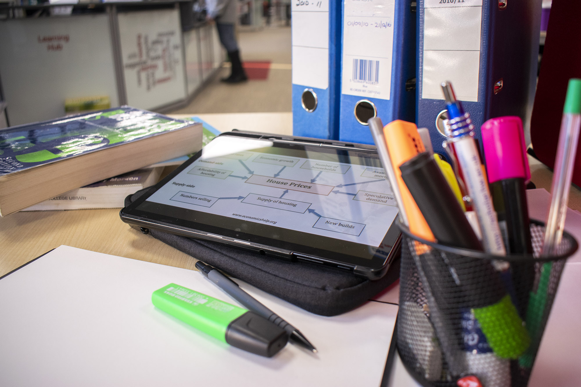 iPad on a desk next to folders