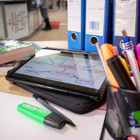 iPad on a desk next to folders