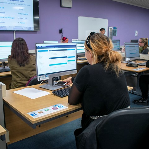 Business Administration and Information Technology students working on computers