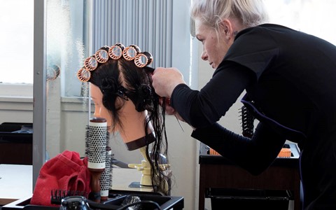 hairdressing student working with model head