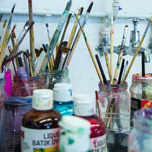 Paintbrushes in jars at a sink