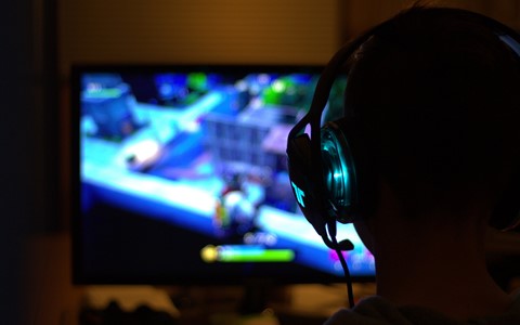 person with headset playing computer game