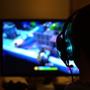 person with headset playing computer game
