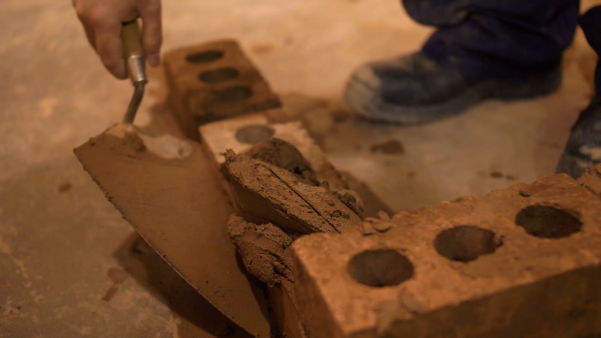 Someone applying grout to a brick wall with a trowel