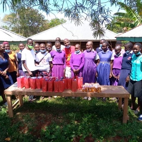 A group of students from a school in Kenya receiving free period products from the college
