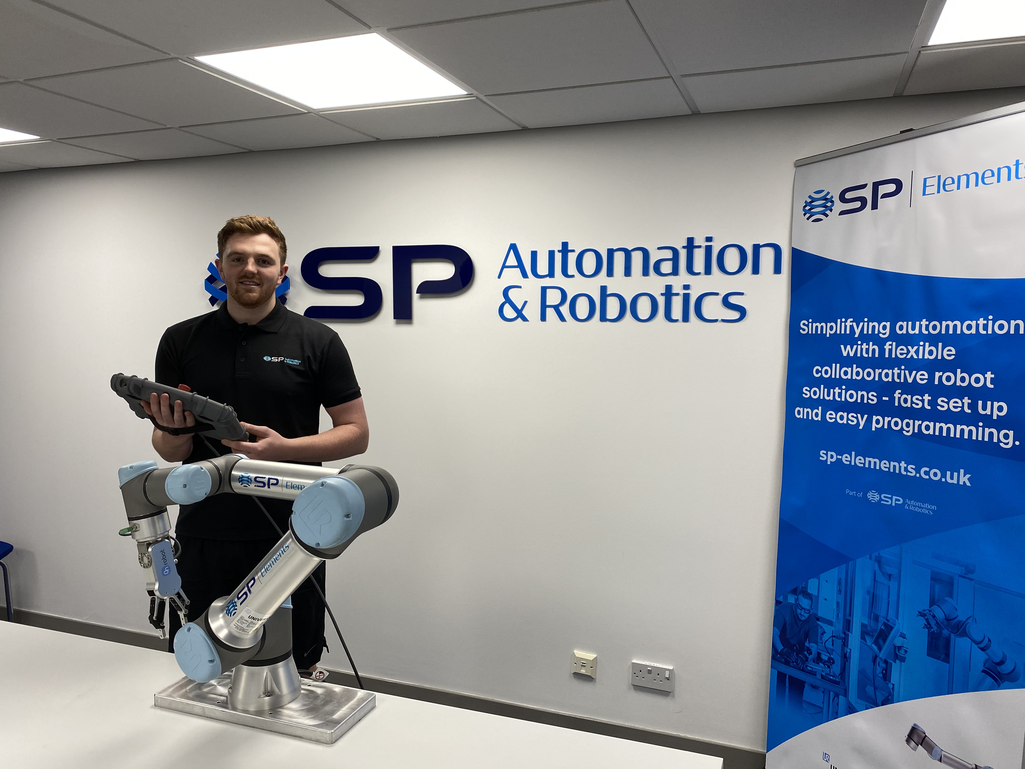 Braden Henderson posing by robotic arm