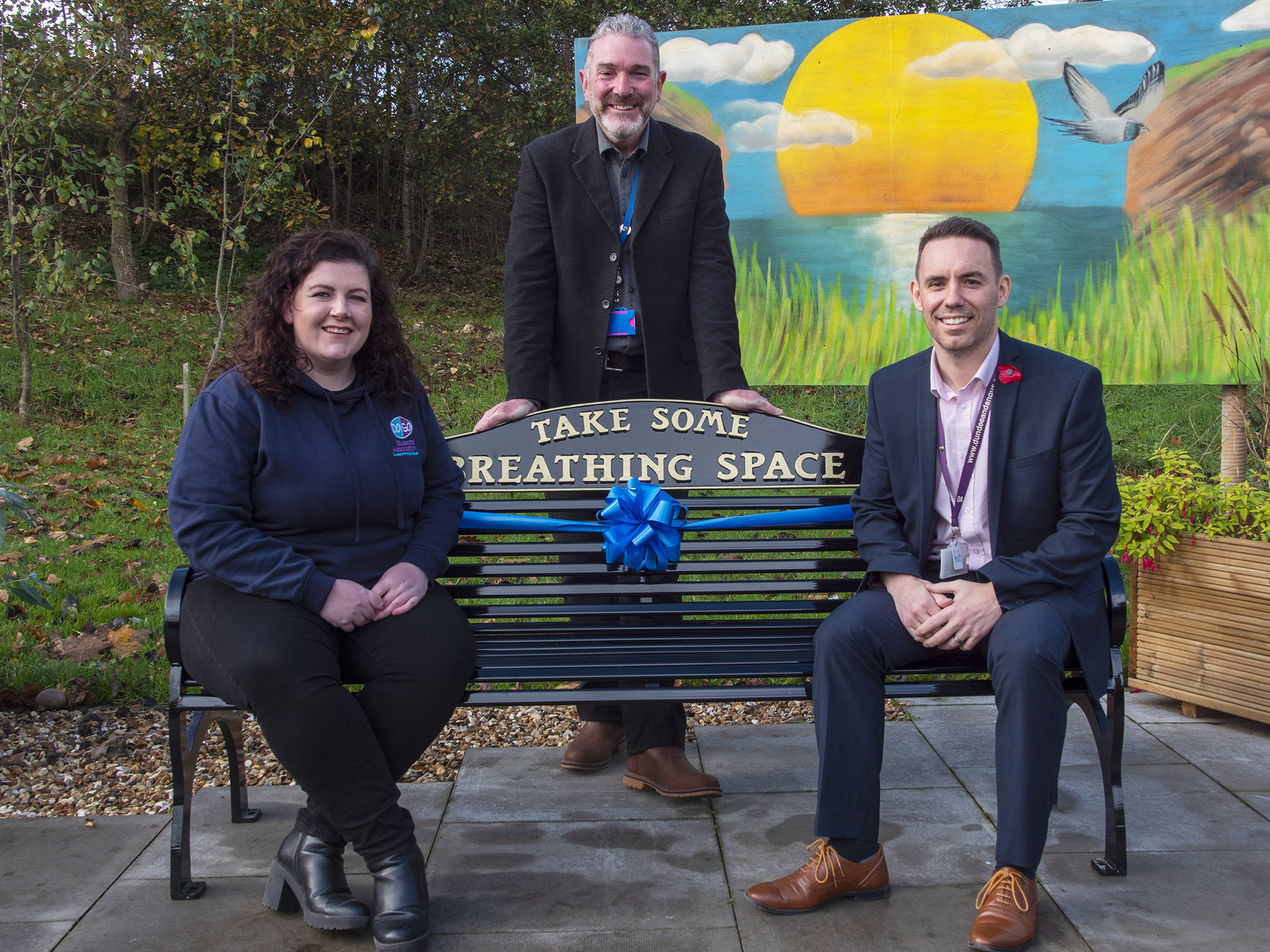 Amy Monks, Simon Hewwitt and the head of Breathing space sitting on the new bench