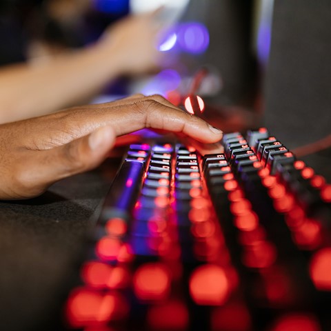 man typing on lightup keyboard