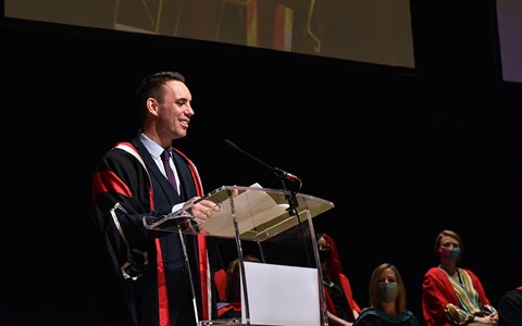 Principal Simon Hewitt speaking on stage