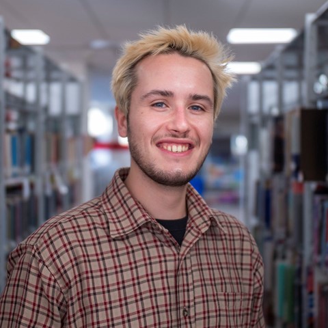 student smiling in college library