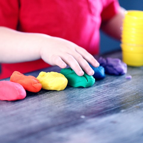 closeup of child playing with playdough