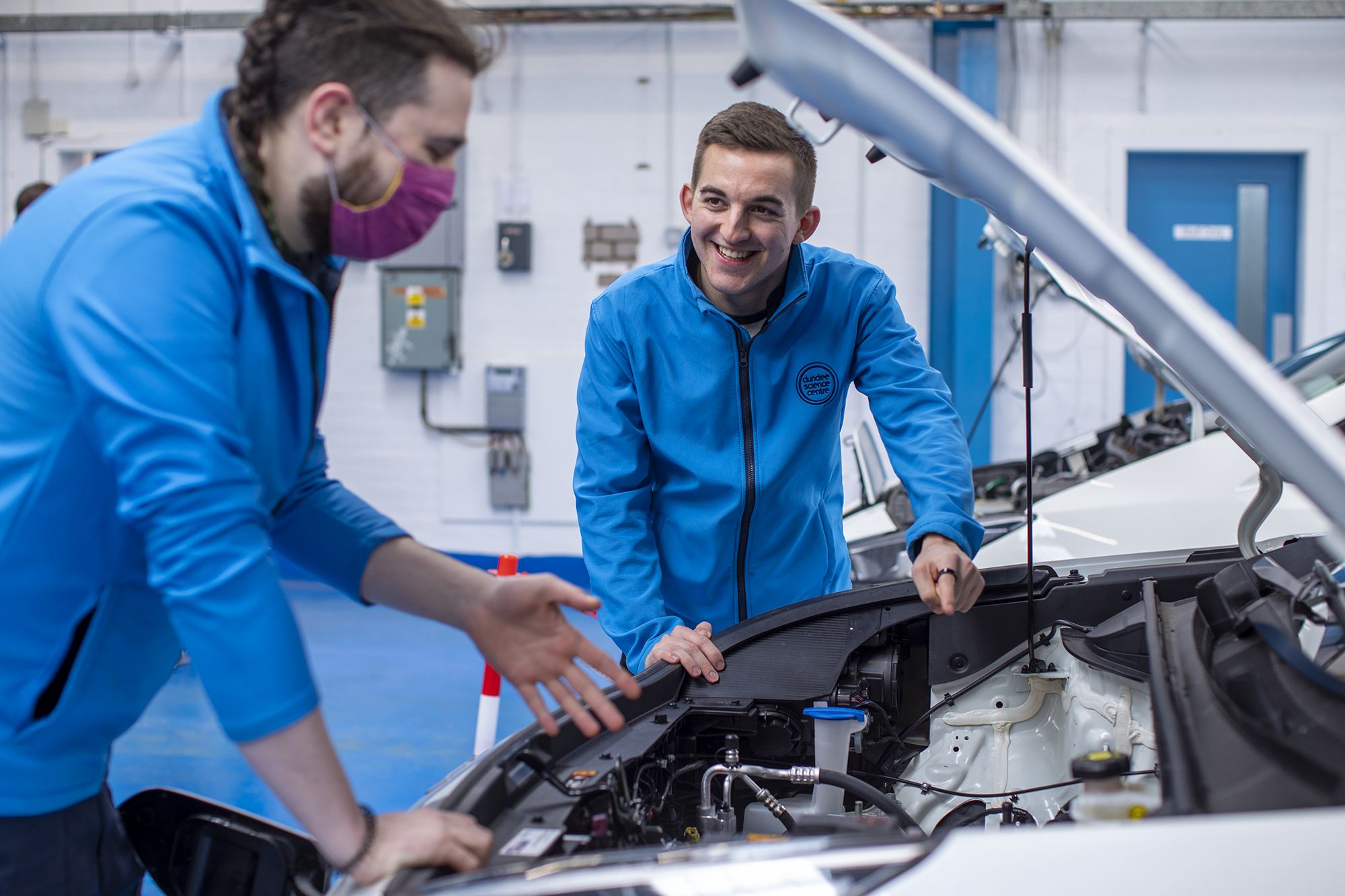 Science Centre Employees under the hood of an Electric Vehicle