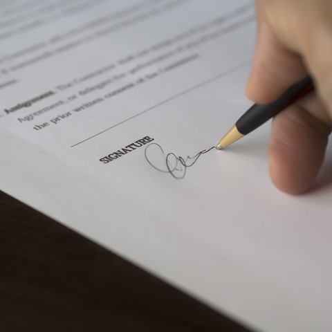 closeup of a document being signed