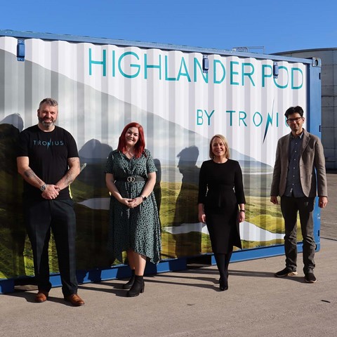 Partnership standing in front of Highlander pod