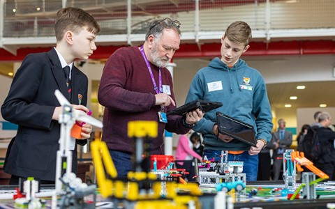 Pupils working with lecturer on Lego League task