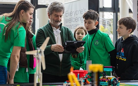 Pupils listening to lecturer during Lego League tournament