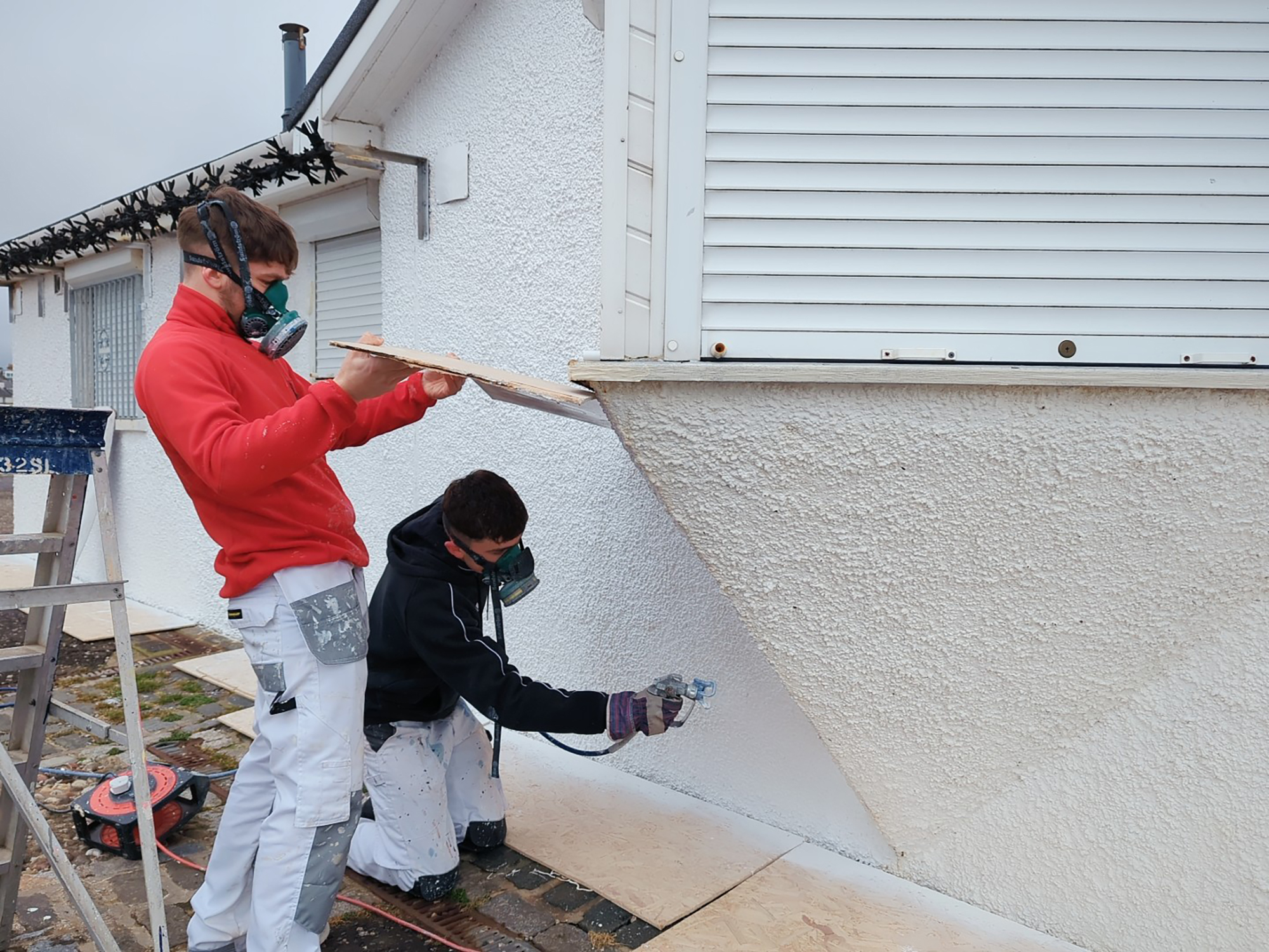 painting and decorating students painting wall