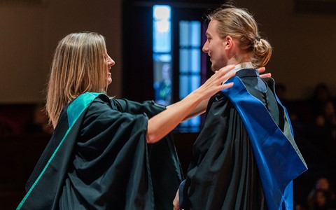 graduating student receiving hood