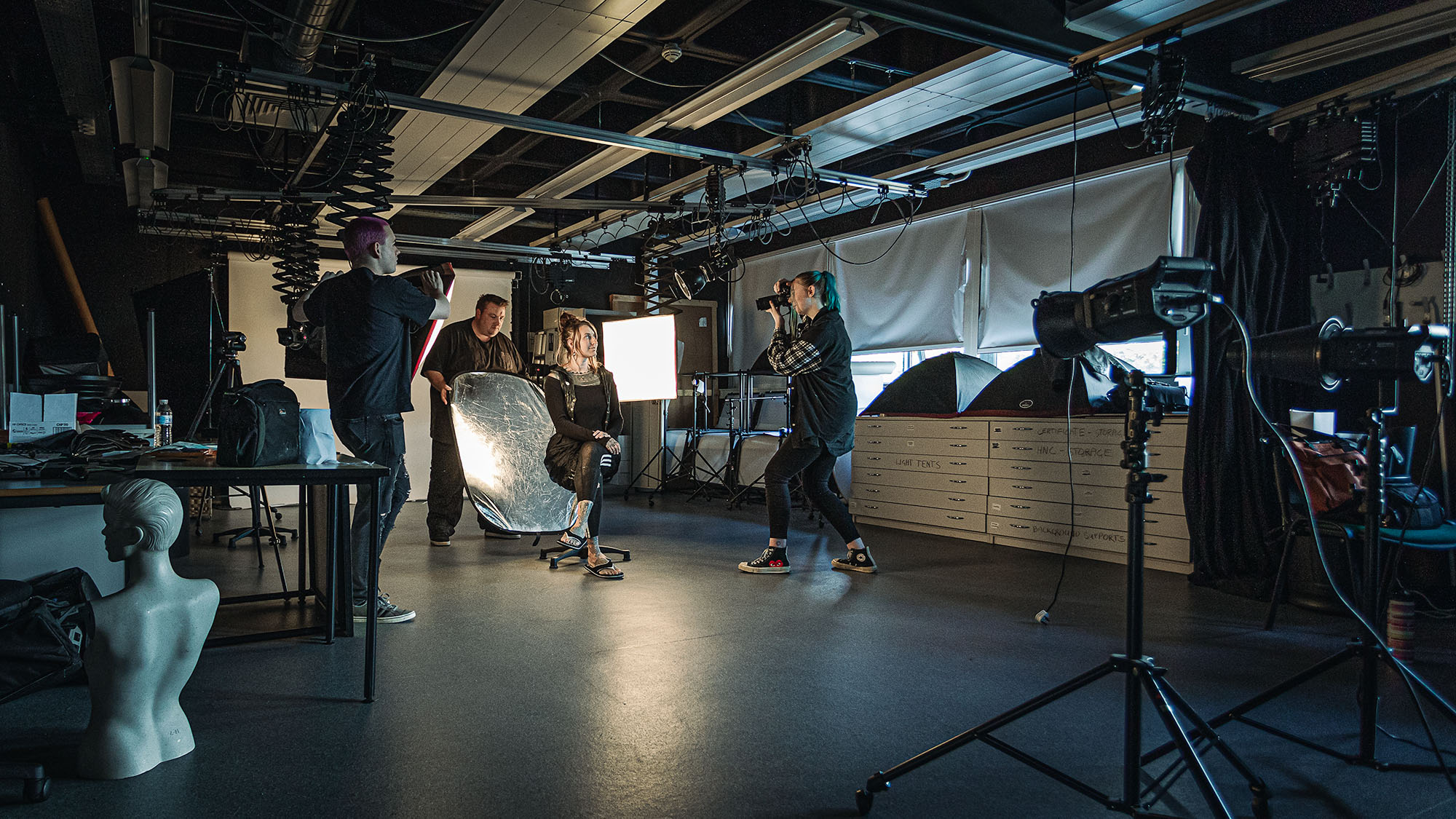 Students in photography studio taking woman's photo