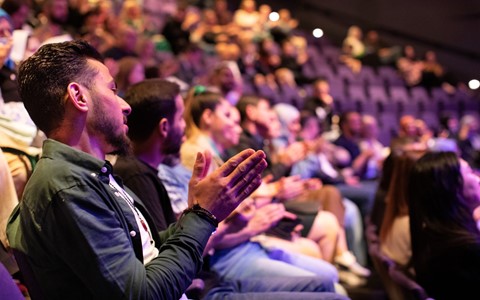 Audience clapping in a theatre