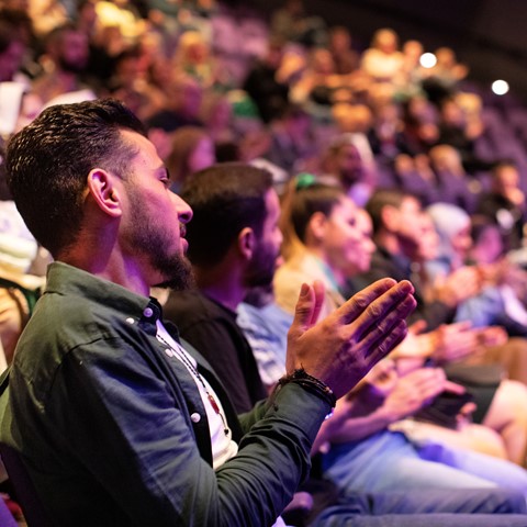 Audience clapping in a theatre