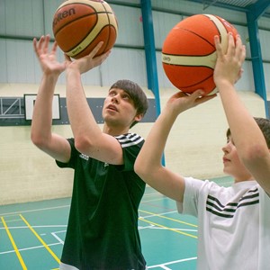 Student working with child on basketball skills