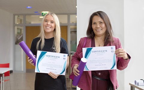 Two PDA Healthcare students holding their certificates