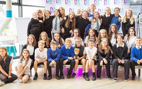 Photo of class of school pupils posting with BAFTA trophy