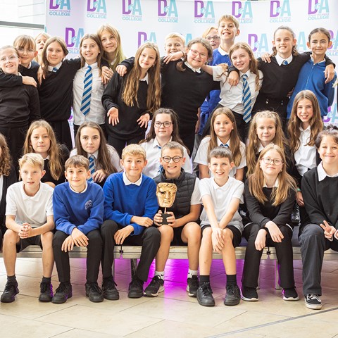 Photo of class of school pupils posting with BAFTA trophy