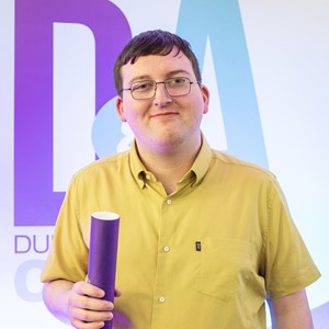 Student holding D&A certificate tube