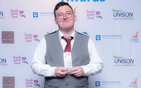 Student at NHS Star Awards holding trophy