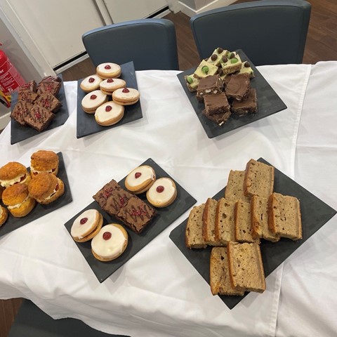 selection of cakes on a table including scones and empire biscuits 