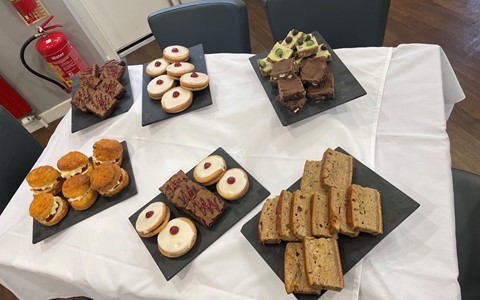 selection of cakes on a table including scones and empire biscuits