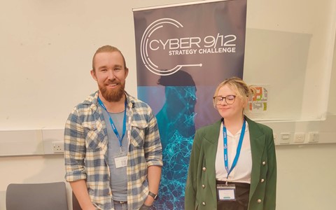 Students standing in front of cyber pop-up banner