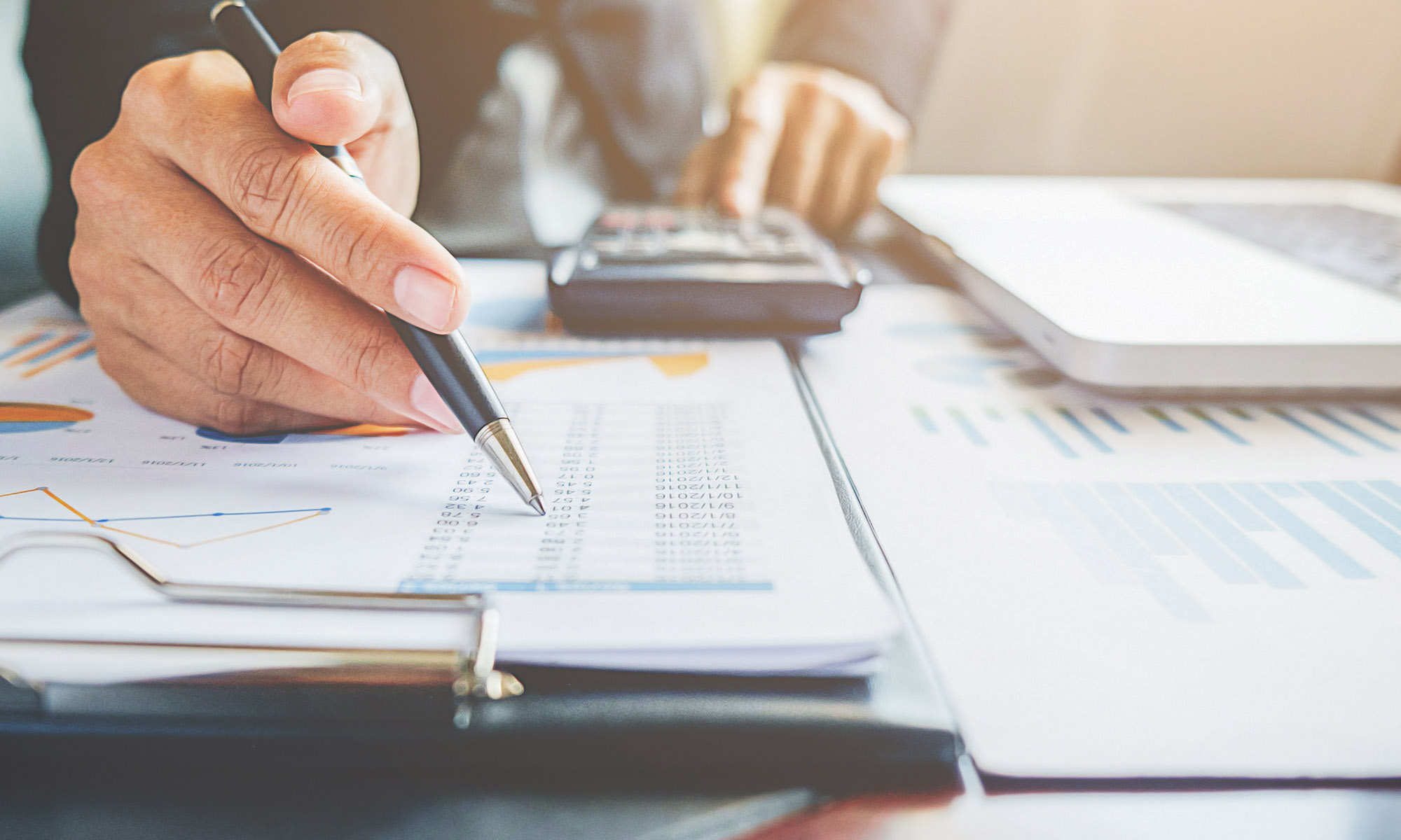 notes with numbers, calculator and laptop