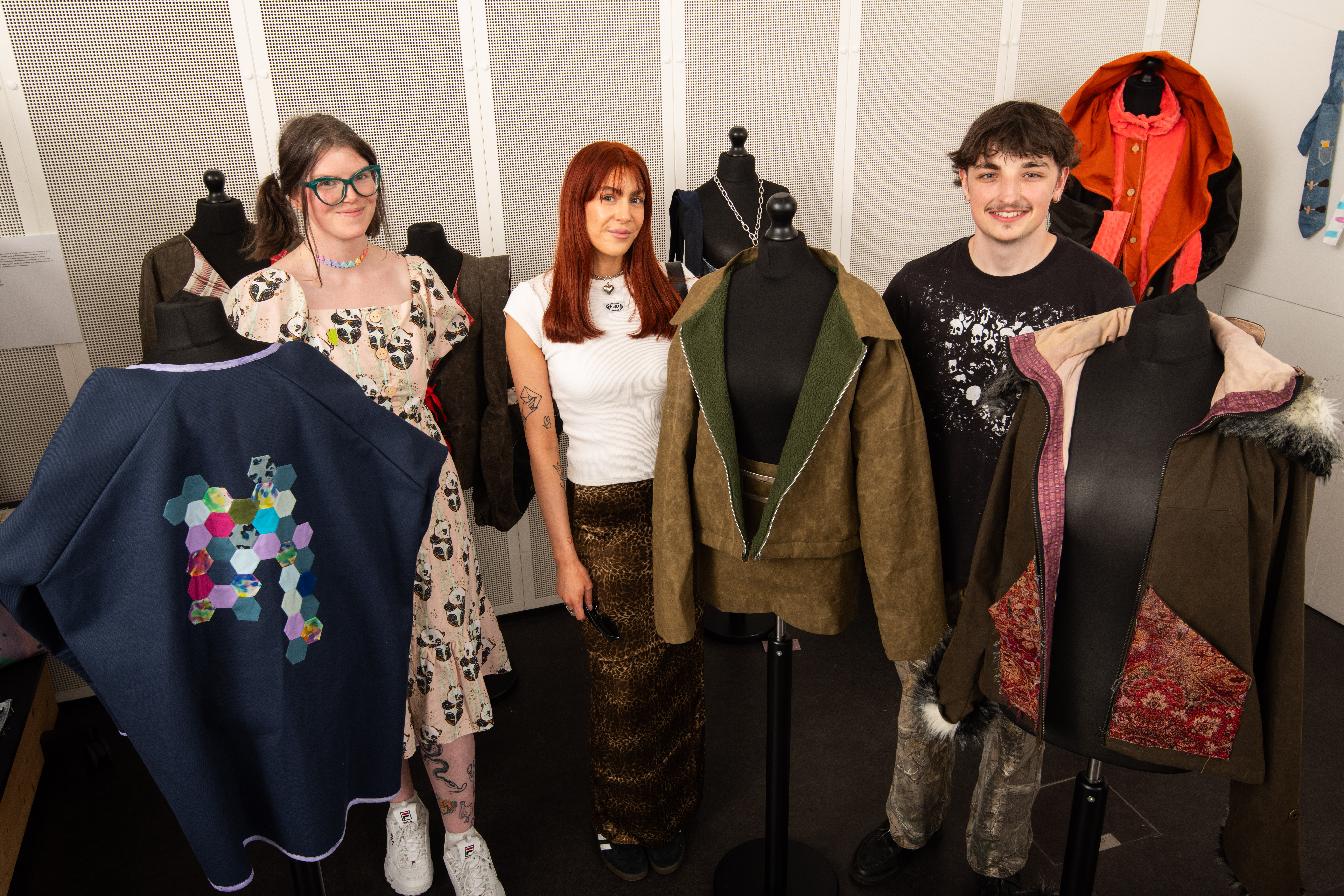 Textiles students posing with clothing created for exhibition