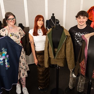 Textiles students posing with clothing created for exhibition