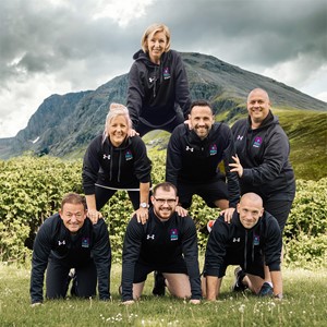 Seven members of the Sports and Fitness Team at Dundee and Angus College in a pyramid shape in front a mountain 