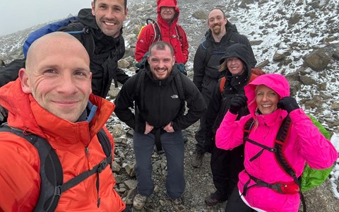Seven members of the Sports and Fitness Team at Dundee and Angus College on a snowy mountain looking happy but cold