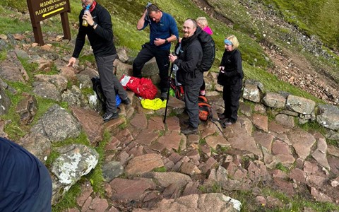 Five members of D&A staff climbing a steep path on a mountain