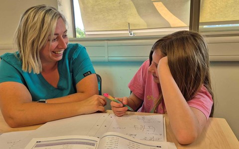 Mother and Daughter smiling whilst working together on maths homework in the Homework Club