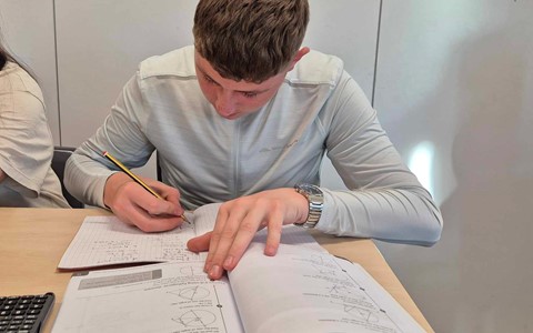 Young student working hard on National 5 maths from a workbook
