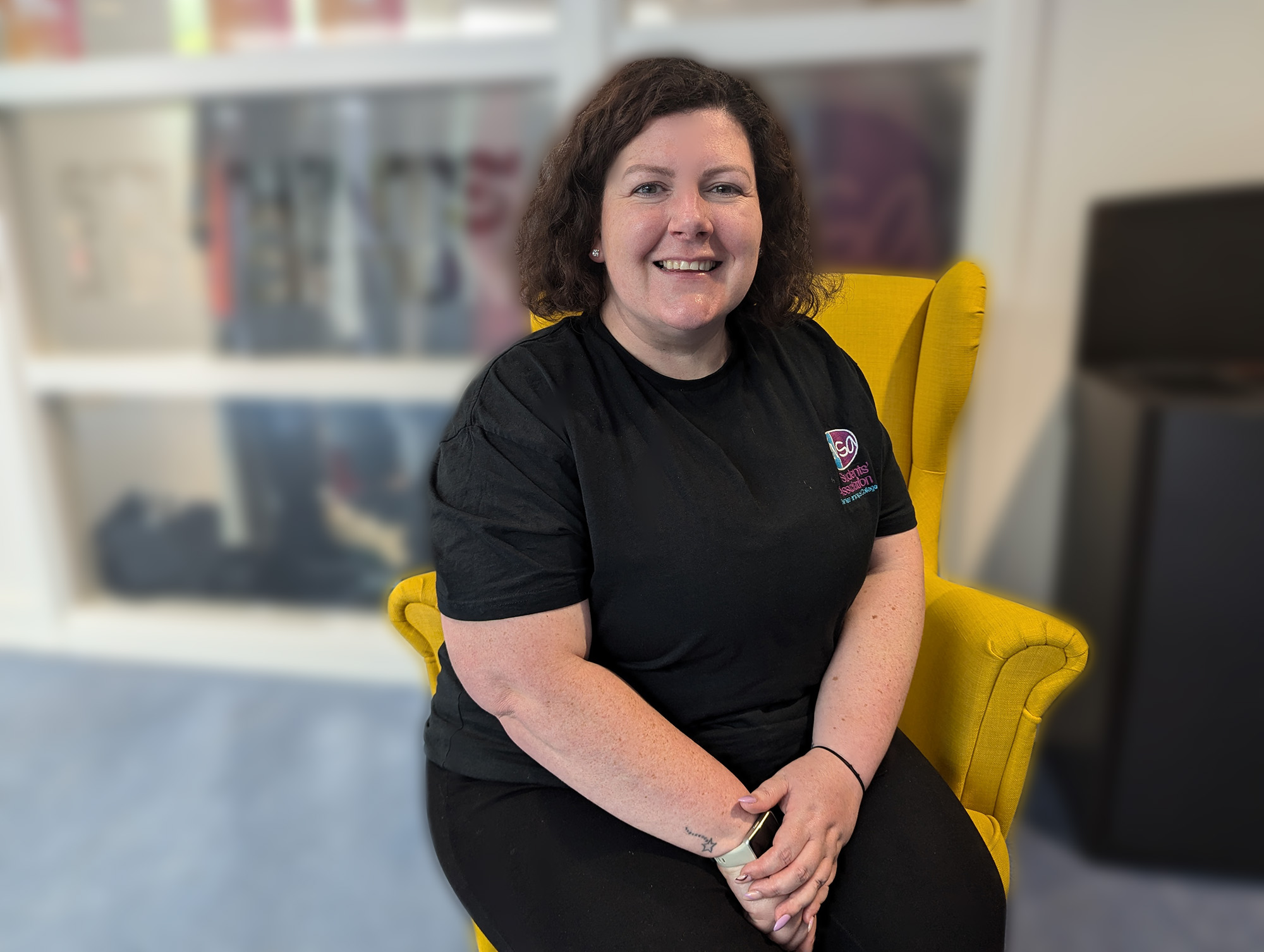 Amy Monks sitting in yellow chair in front of students' association office